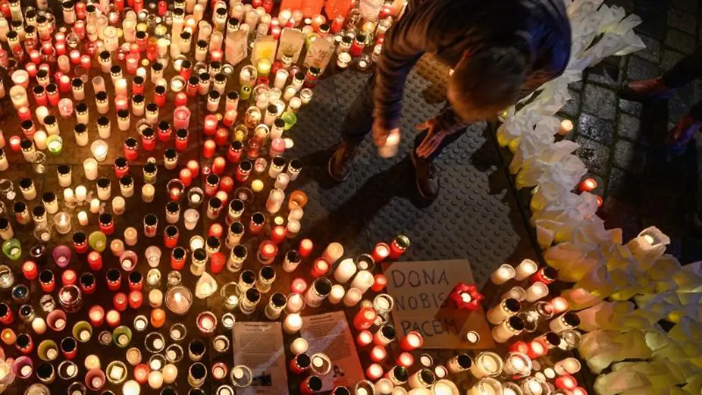 Ein-Mann-legt-eine-Kerze-vor-der-Frauenkirche-nieder