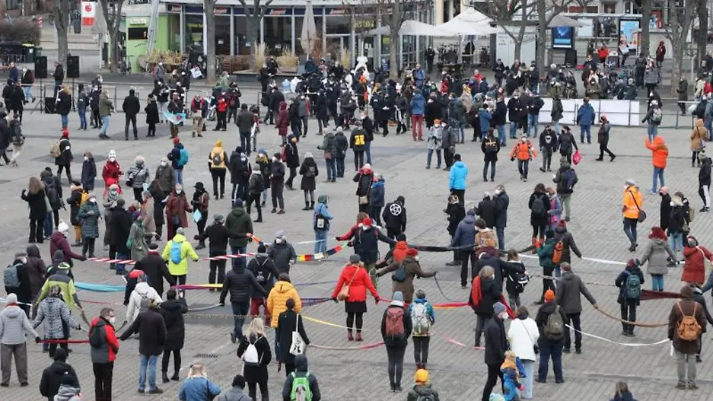 Menschen-bilden-als-Zeichen-gegen-die-sogenannten-Spaziergaenge-eine-Menschenkette-vor-dem-Erfurter-Dom