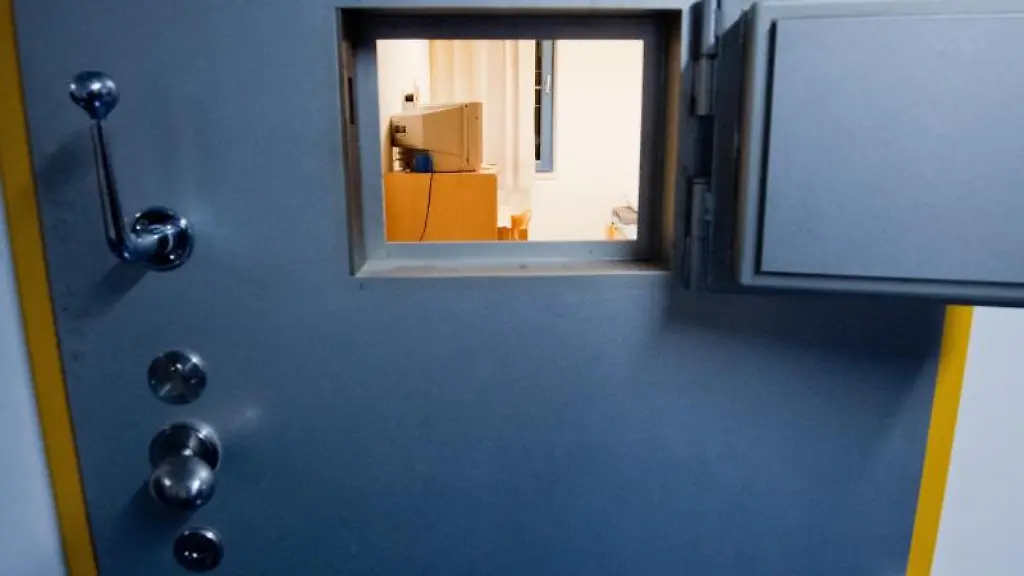 Ein-kleines-Fenster-in-einer-Zellentuer-gewaehrt-einen-Einblick-in-eine-Gefaengniszelle