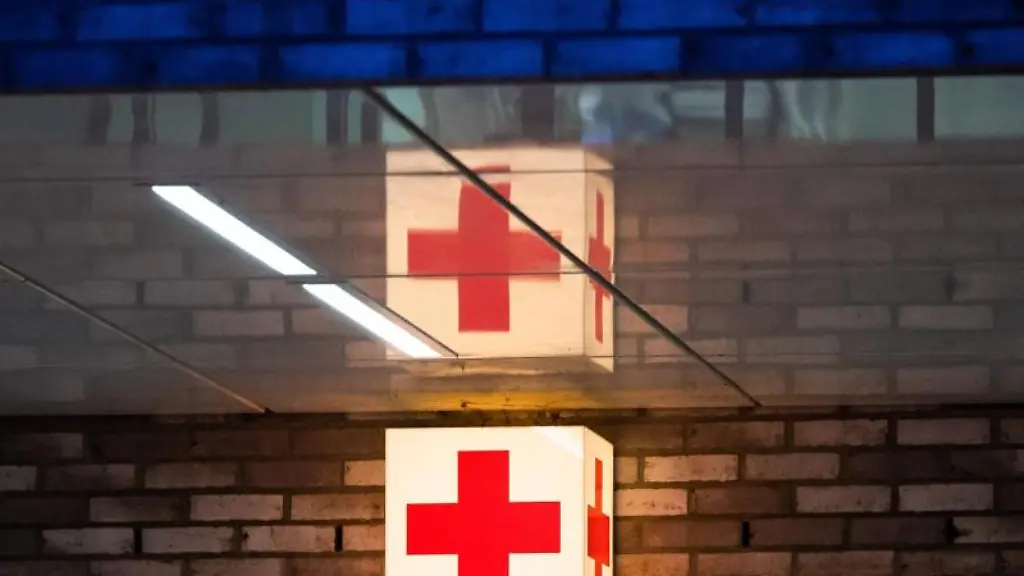 Ein-Leuchtkasten-mit-einem-roten-Kreuz-haengt-vor-der-Notaufnahme-eines-Krankenhauses