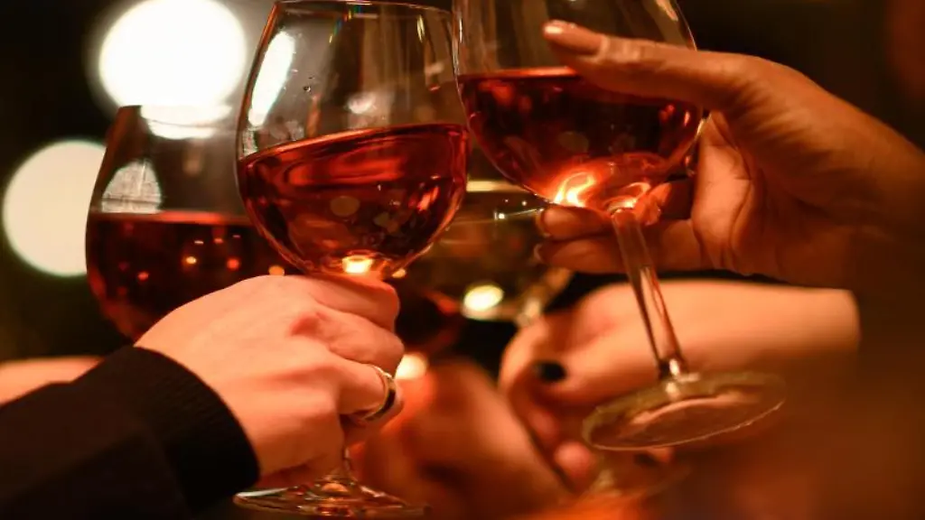 Gaeste-stossen-in-einem-Restaurant-mit-ihren-Weinglaesern-an