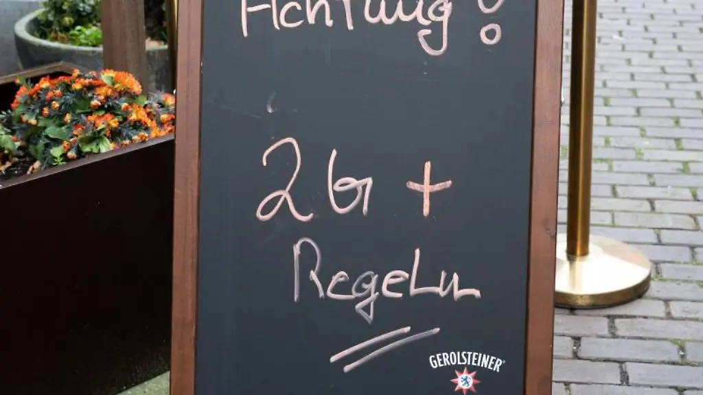 Ein-Schild-vor-einem-Restaurant-weist-auf-das-Gelten-der-2G-plus-Regel-hin