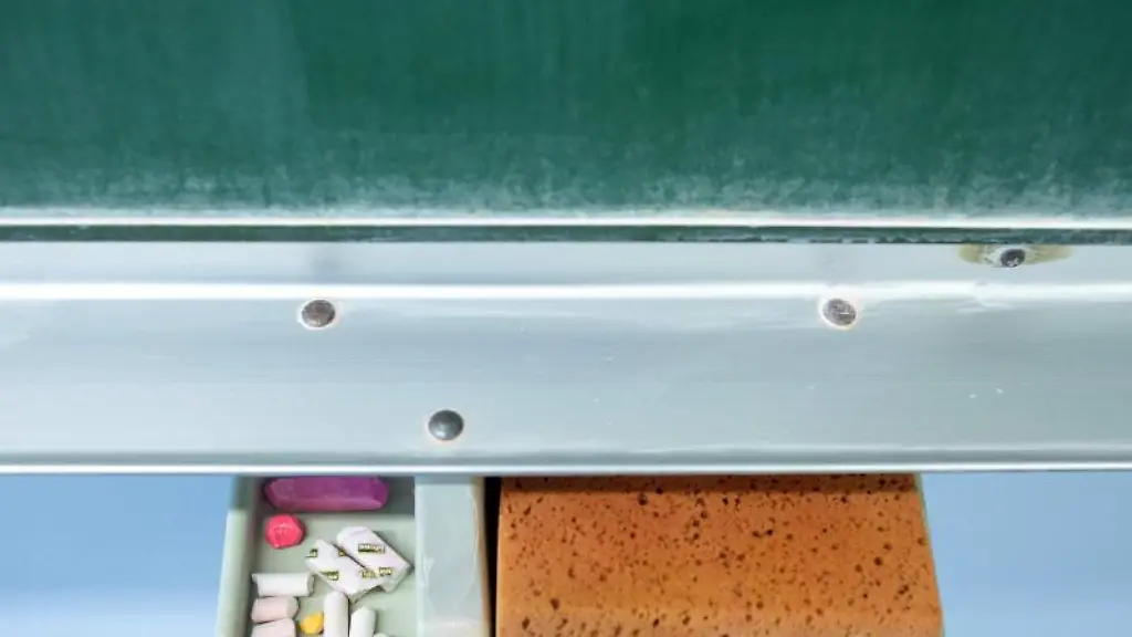 Schwamm-und-Kreide-liegen-in-einem-Klassenraum-unter-einer-Tafel