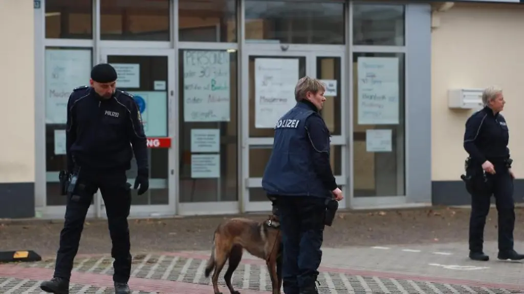 Einsatzkraefte-der-Polizei-stehen-mit-einem-Spuerhund-vor-dem-Impfzentrum-in-Quedlinburg