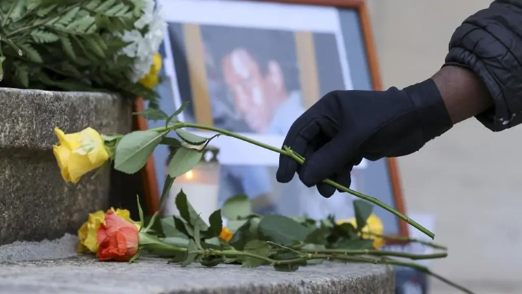 Eine-Frau-legt-eine-Rose-zum-Gedenken-an-Oury-Jalloh-auf-die-Stufen-des-Reviers