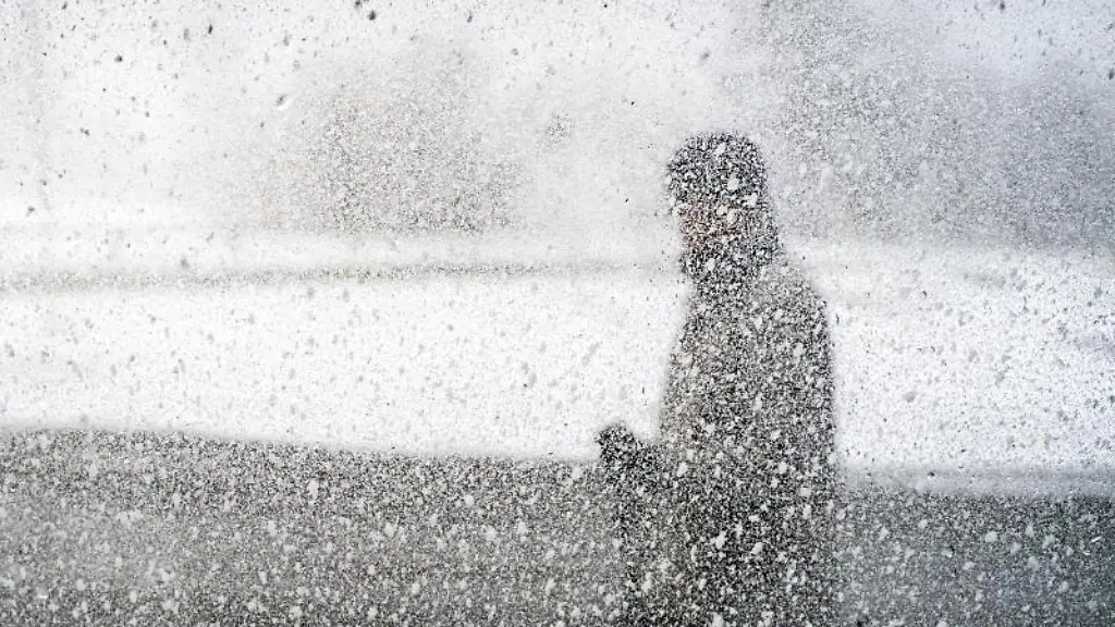 Ein-Wander-geht-auf-dem-schneebedeckten-Gipfel-des-Grossen-Feldbergs-im-Taunus-vorbei