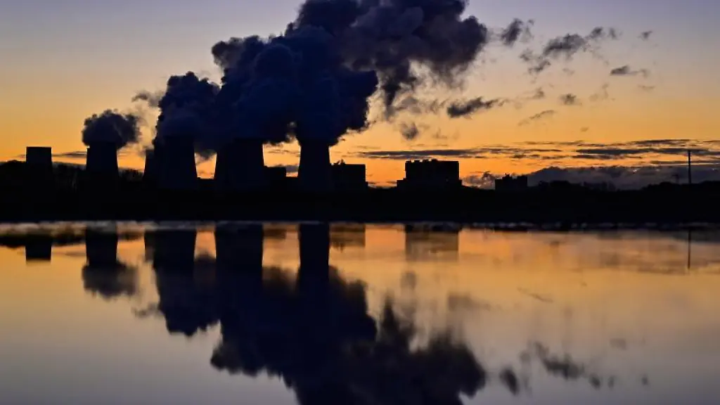 Wasserdampf-steigt-vor-Sonnenaufgang-aus-den-Kuehltuermen-eines-Braunkohlekraftwerks