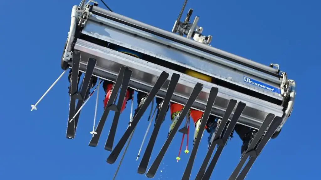 Skifahrer-sitzen-in-einem-Sechser-Lift