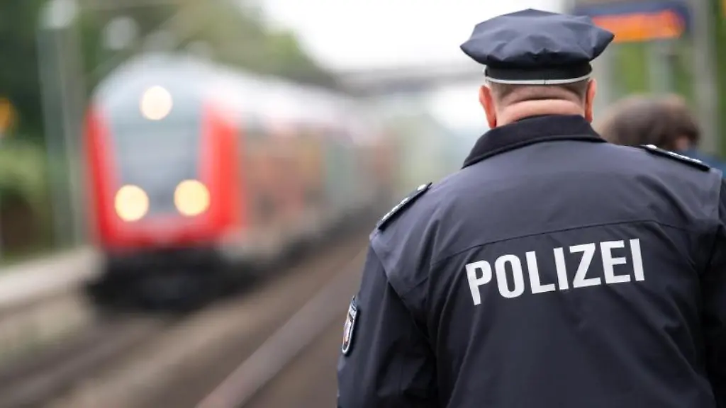 Ein-Polizist-laeuft-ueber-einen-Bahnsteig