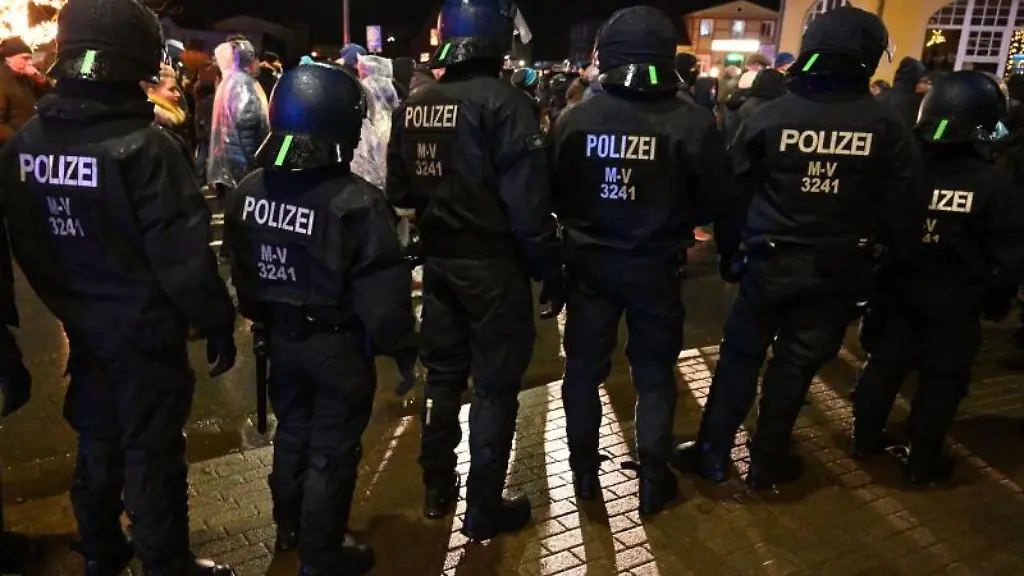 Polizisten-stehen-neben-Teilnehmern-der-Corona-Demo-in-Wolgast
