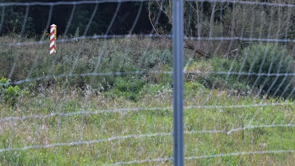 Ein-polnischer-Grenzpfeiler-ist-hinter-einem-Drahtzaun-gegen-die-Afrikanische-Schweinepest-nahe-dem-deutsch-polnischen-Grenzfluss-Neisse-zu-sehen