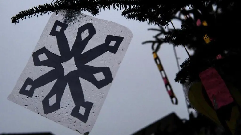 Eine-vollgeregnete-laminierte-Schneeflocke-haengt-an-einem-Weihnachtsbaum