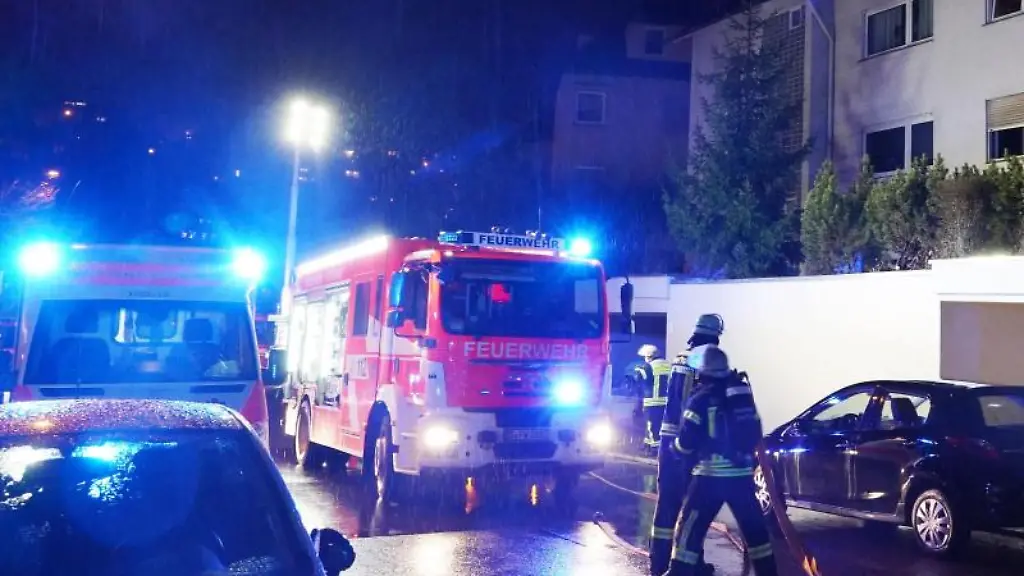 Einsatzkraefte-der-Feuerwehr-Rettungskraefte-und-Polizei-stehen-vor-dem-Mehrfamilienhaus