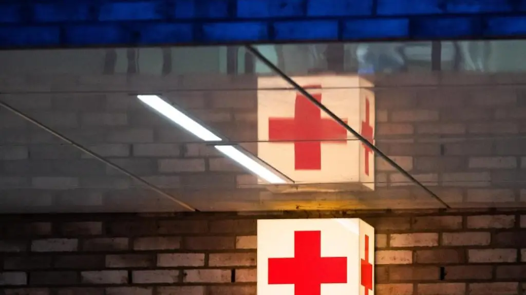Ein-Leuchtkasten-mit-einem-roten-Kreuz-haengt-vor-der-Notaufnahme-eines-Krankenhauses