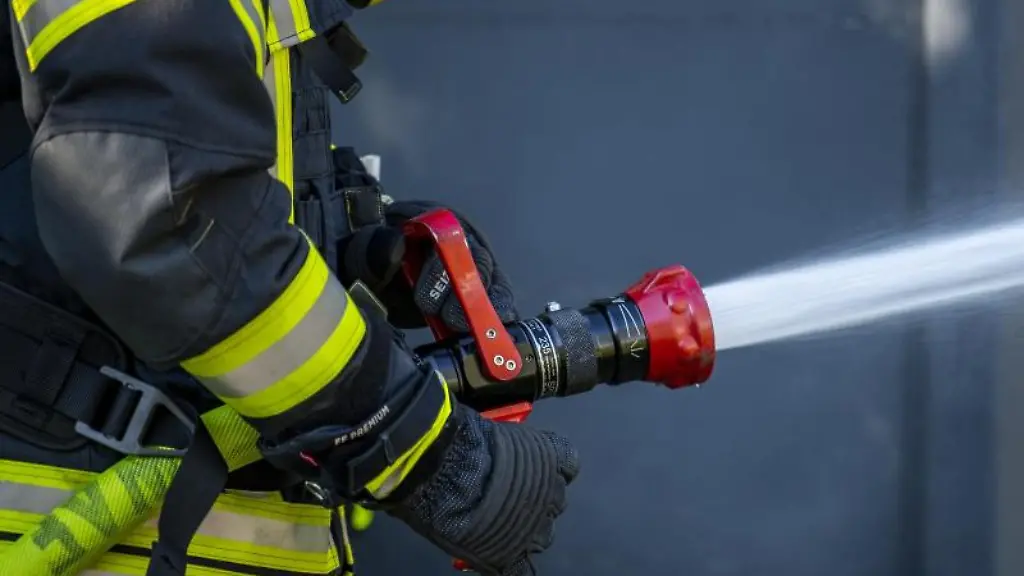 Ein-Mitglied-der-Feuerwehr-spritzt-aus-einem-Schlauch-mit-Wasser