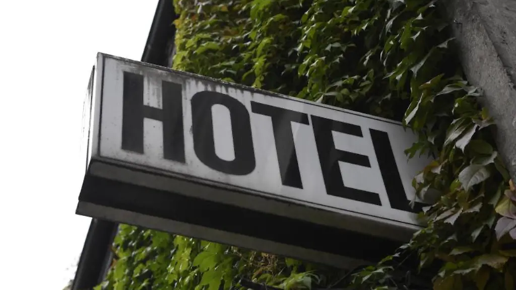 Ein-Leuchtschild-haengt-an-der-Fassade-eines-Hotels