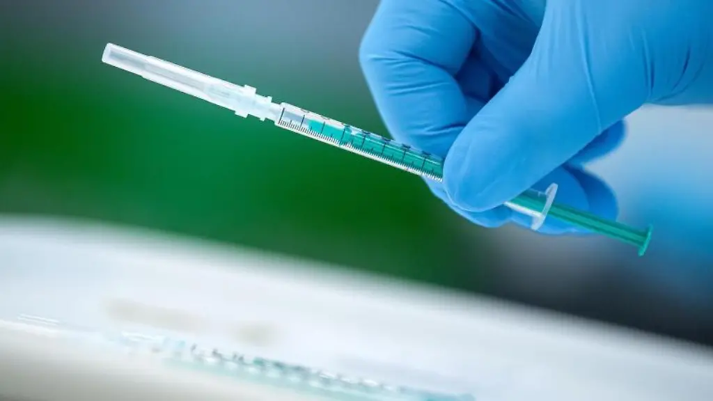 Ein-medizinischer-Mitarbeiter-haelt-eine-Impfspritze-in-der-Hand