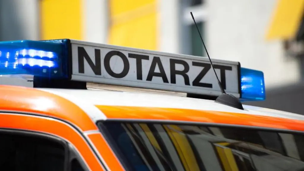 Ein-Notarztwagen-steht-mit-eingeschaltetem-Blaulicht-auf-der-Strasse