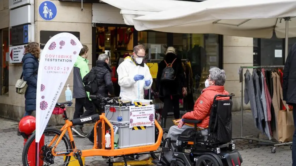 Intensivpfleger-Oliver-Sablowski-M-testet-eine-Passantin-mit-einem-Antigen-Schnelltest