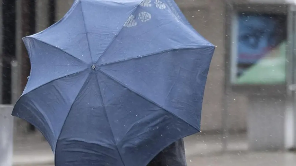 Ein-Passant-schuetzt-sich-mit-einem-Regenschirm