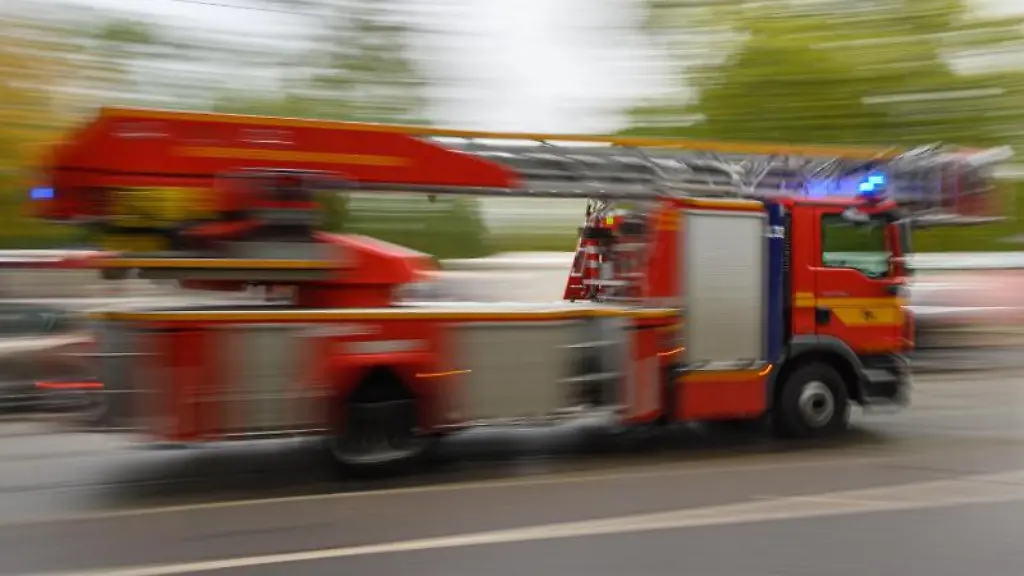 Ein-Feuerwehrfahrzeug-mit-Drehleiter-faehrt-zu-einem-Einsatz