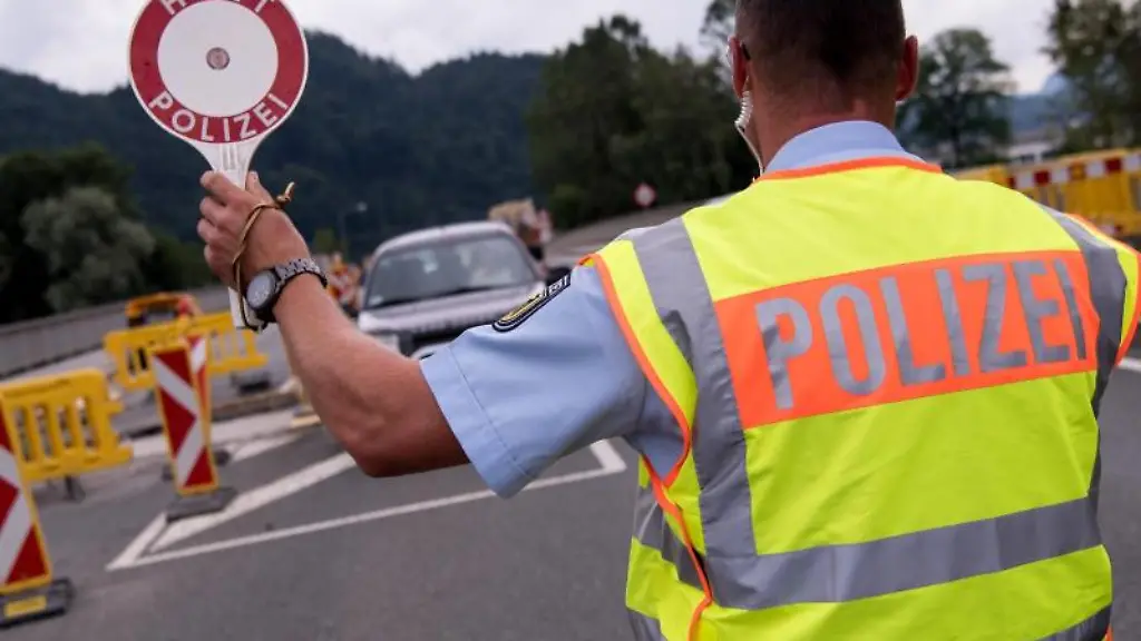 Polizisten-kontrollieren-an-einer-mobilen-Kontrollstelle-kurz-hinter-einer-Grenze-Fahrzeuge