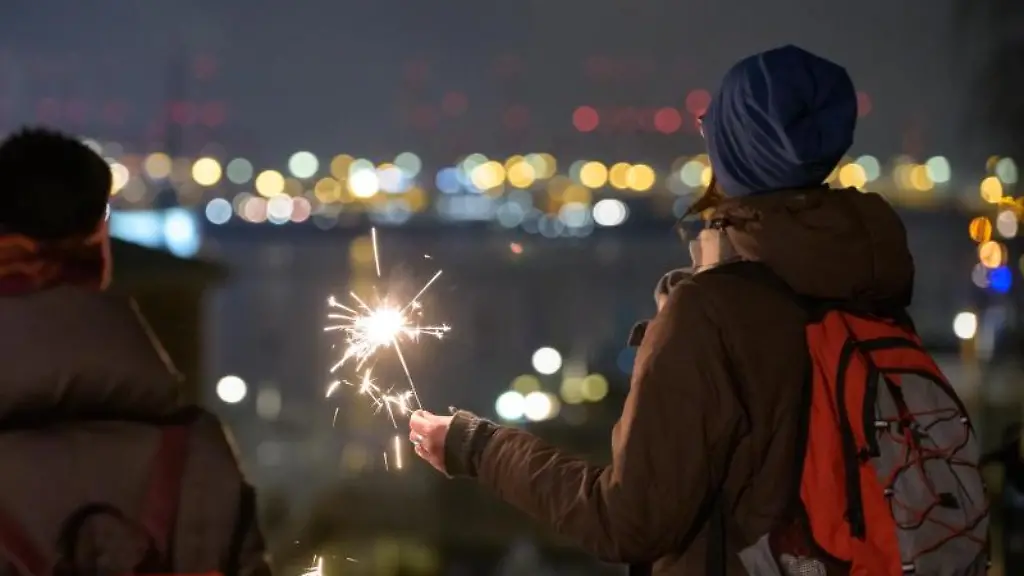 Eine-Frau-hat-kurz-nach-dem-Jahreswechsel-eine-Wunderkerze-gezuendet-und-schaut-auf-das-Hafenpanorama