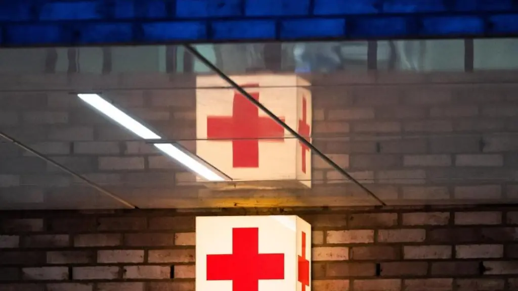 Ein-Leuchtkasten-mit-einem-roten-Kreuz-haengt-vor-der-Notaufnahme-eines-Krankenhauses