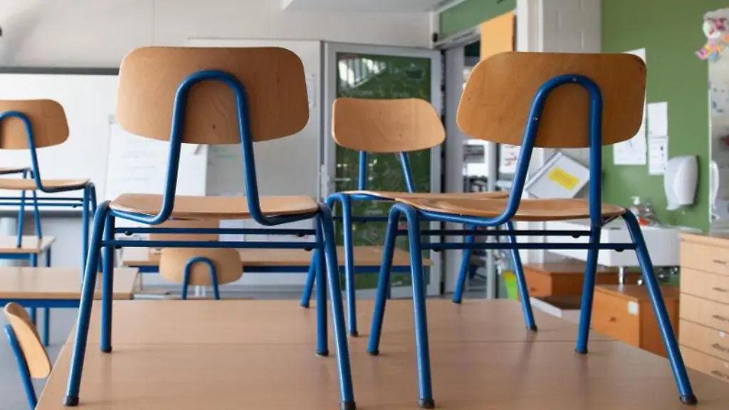 Stuehle-stehen-in-einem-Klassenzimmer-auf-den-Tischen