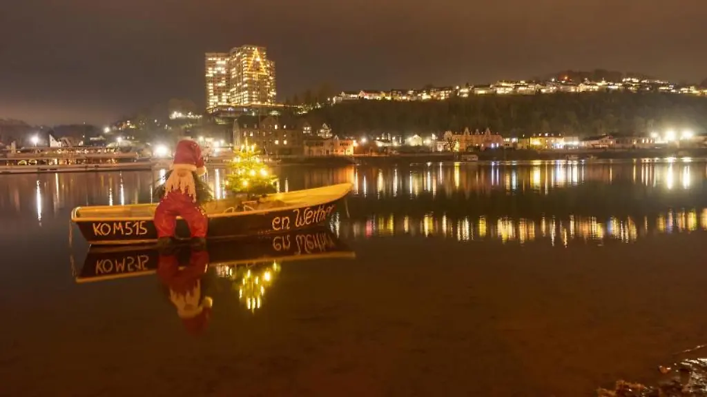 Ein-mit-einem-Tannenbaum-und-ein-weihnachtlich-geschmuecktes-Boot-liegt-am-Mittelrhein