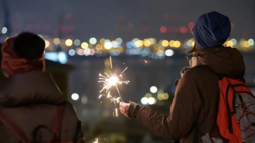 Eine-Frau-haelt-eine-Wunderkerze-in-der-Hand-und-schaut-auf-das-Hafenpanorama