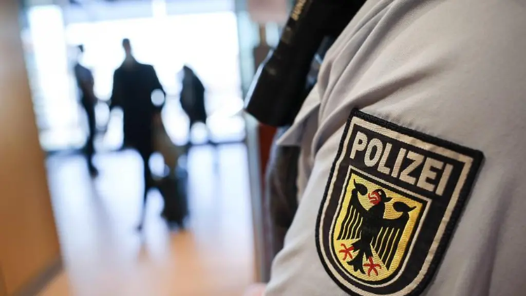 Ein-Beamter-der-Bundespolizei-kontrolliert-Reisende-am-Flughafen