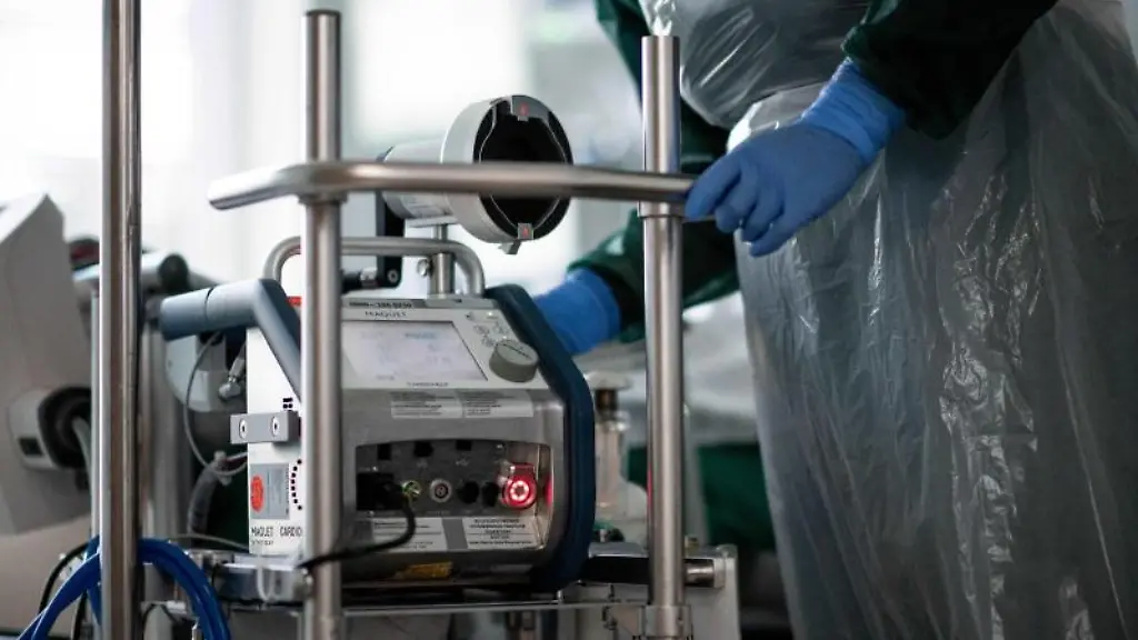 Eine-Pflegekraft-steht-auf-einer-Intensivstation-in-einem-Zimmer-und-bedient-eine-Herz-Lungen-Maschine