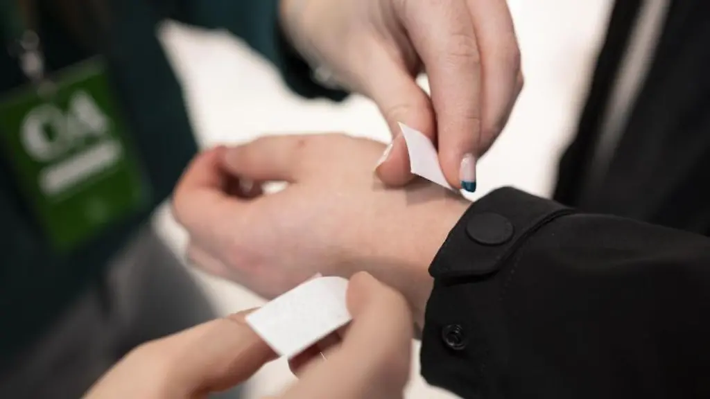 Eine-Mitarbeitern-wickelt-einem-Kunden-2G-Baendchen-um-das-Handgelenk