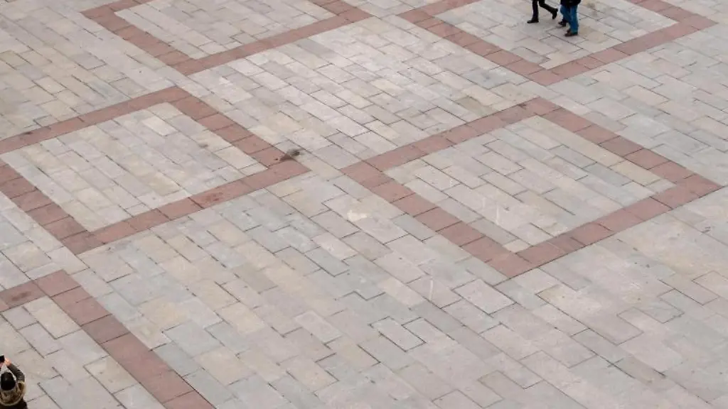 Passanten-gehen-ueber-den-fast-leeren-Marienplatz-vor-dem-Rathaus-in-Muenchen