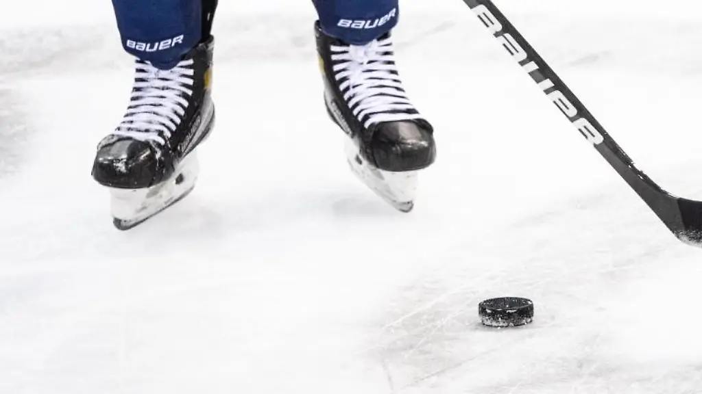 Ein-Eishockeyspieler-spielt-den-Puck