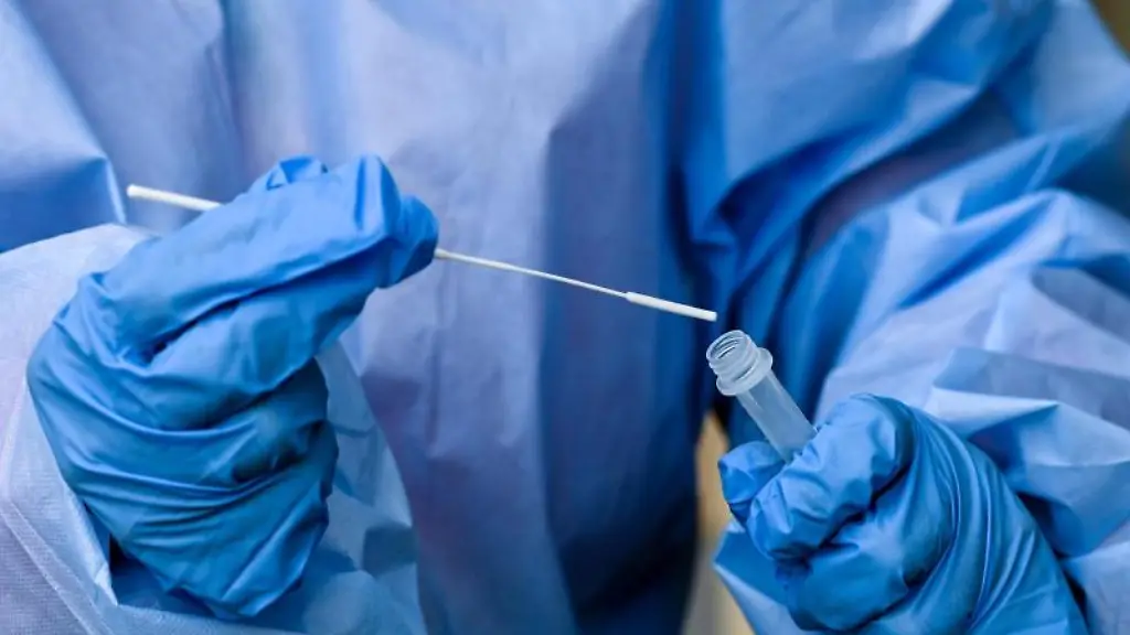 Eine-Pflegekraft-legt-einen-Tupfer-mit-einem-Abstrich-fuer-einen-Corona-Test-in-ein-Testroehrchen
