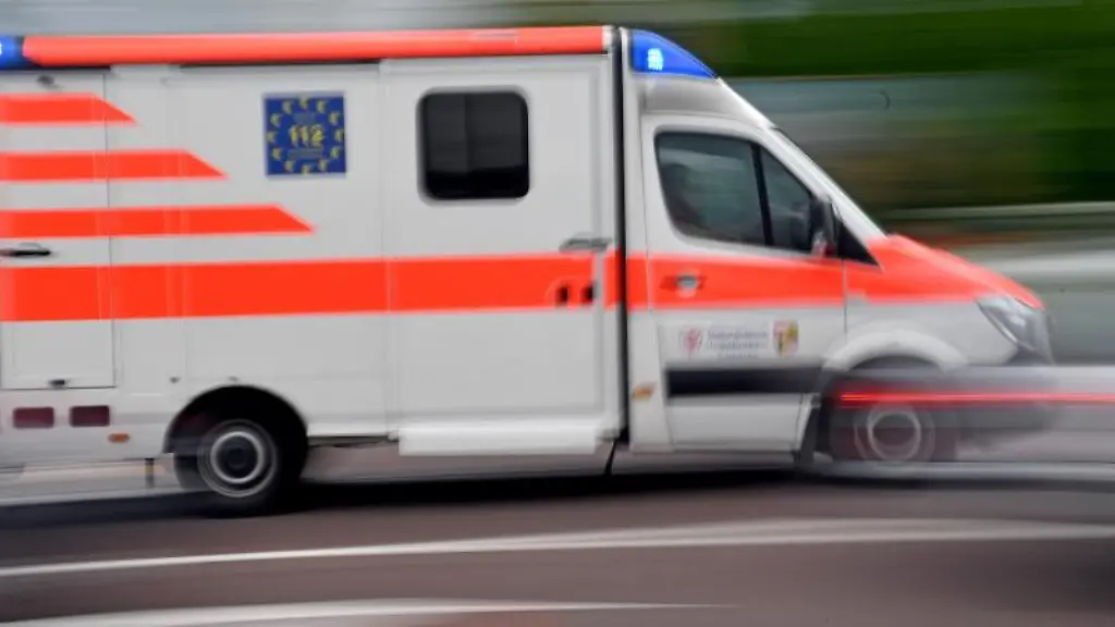 Ein-Krankenwagen-faehrt-mit-Blaulicht-auf-einer-Strasse