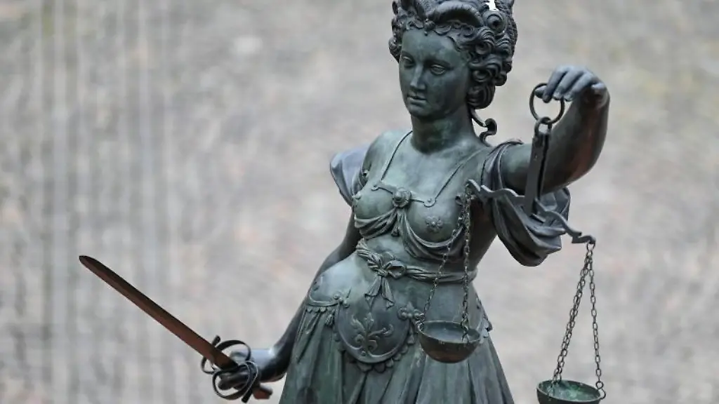 Eine-Statue-der-Justitia-haelt-eine-Waage-und-ein-Schwert-in-der-Hand