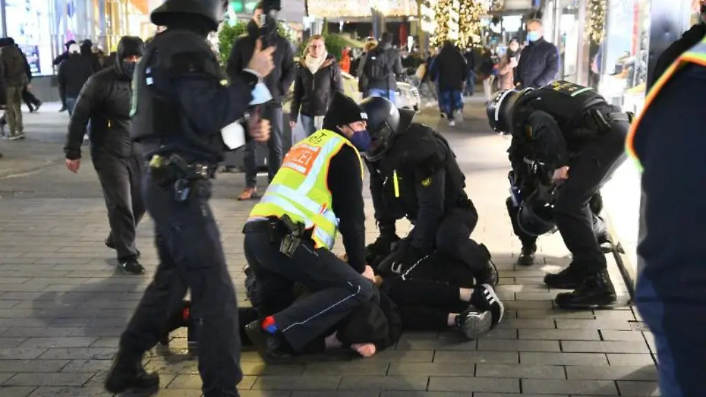 Polizisten-in-Schutzausruestung-ringen-einen-Protestierer-zu-Boden