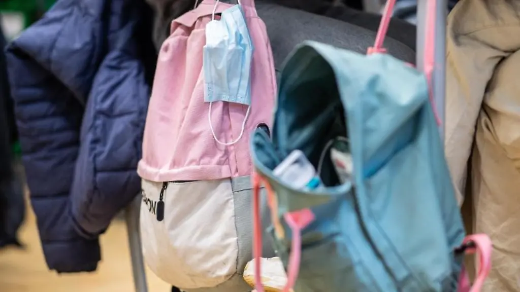 Eine-Maske-haengt-im-Klassenzimmer-am-Rucksack-einer-Schuelerin