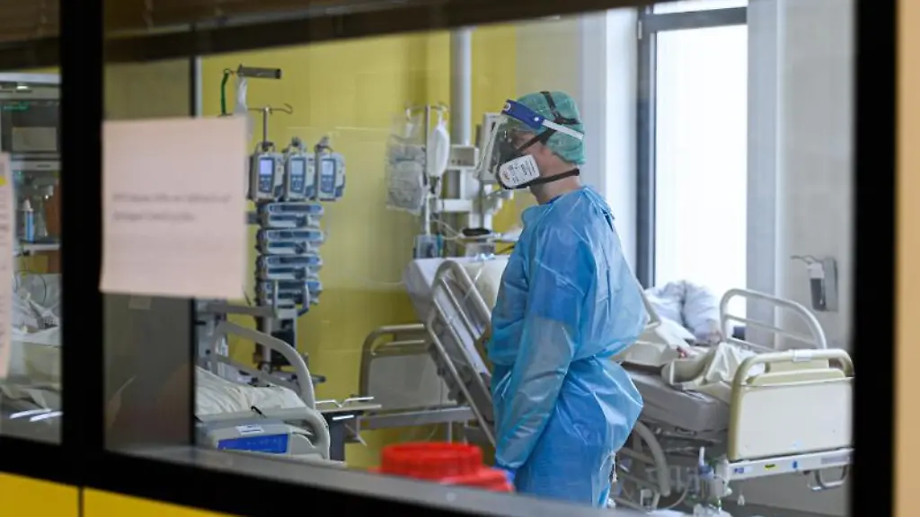 Ein-Pfleger-versorgt-auf-einer-Covid-19-Intensivstation-Corona-Patienten