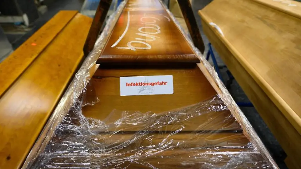Mit-Kreide-geschrieben-steht-Corona-auf-einem-Sarg