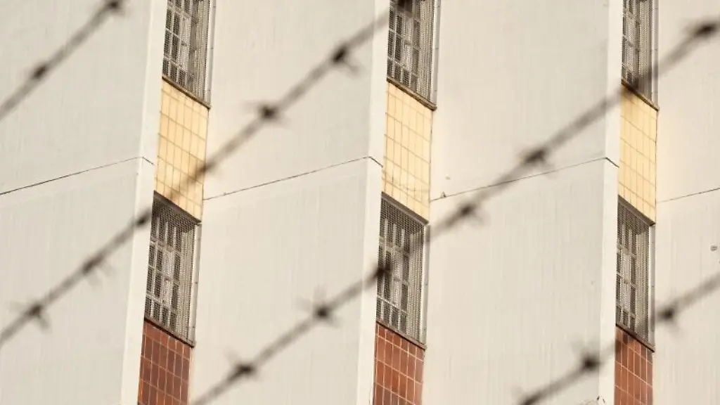 Ein-Stacheldrahtzaun-umzaeunt-das-Gelaende-einer-Justizvollzugsanstalt