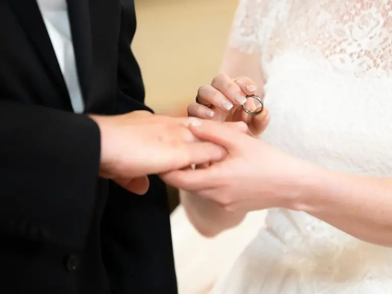 Ein-Brautpaar-steckt-sich-waehrend-ihrer-Trauung-in-der-Kirche-die-Ringe-an