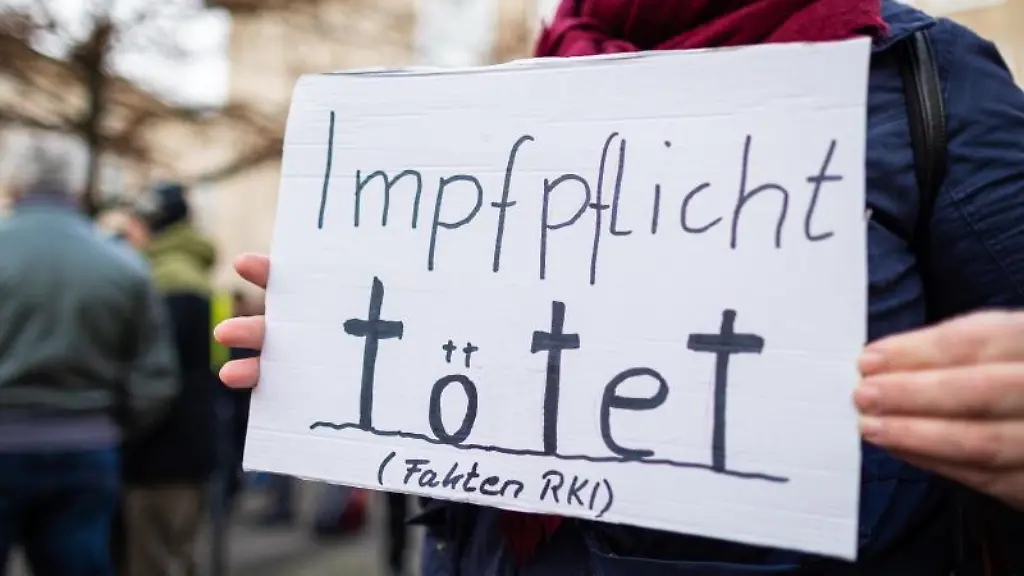 Impfpflicht-toetet-Fakten-RKI-steht-auf-einem-Schild-bei-einer-Kundgebung-gegen-die-Corona-Regeln