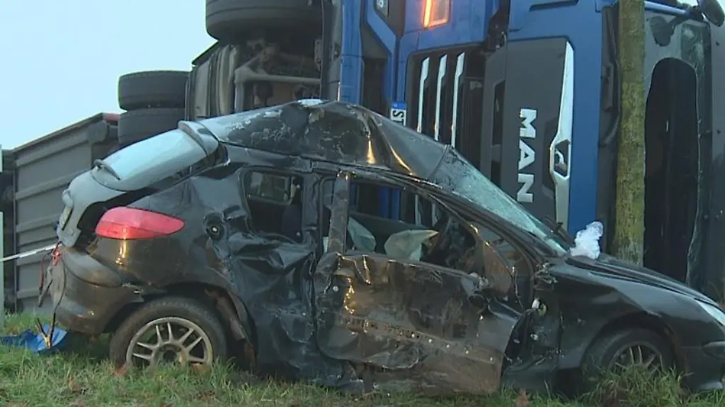 Ein-umgekipper-Lkw-liegt-neben-einem-demolierten-Auto