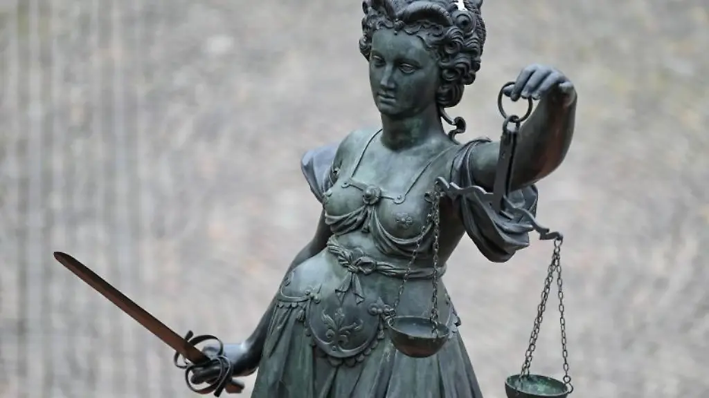 Eine-Statue-der-Justitia-haelt-eine-Waage-und-ein-Schwert-in-der-Hand