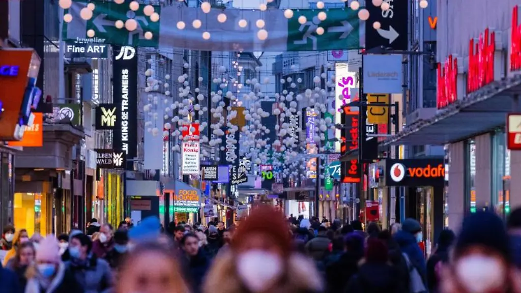 Menschen-gehen-in-der-Daemmerung-ueber-eine-Einkaufsstrasse