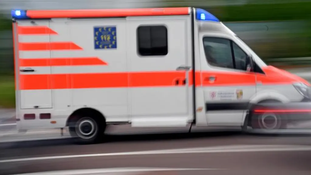 Ein-Krankenwagen-faehrt-mit-Blaulicht-auf-einer-Strasse